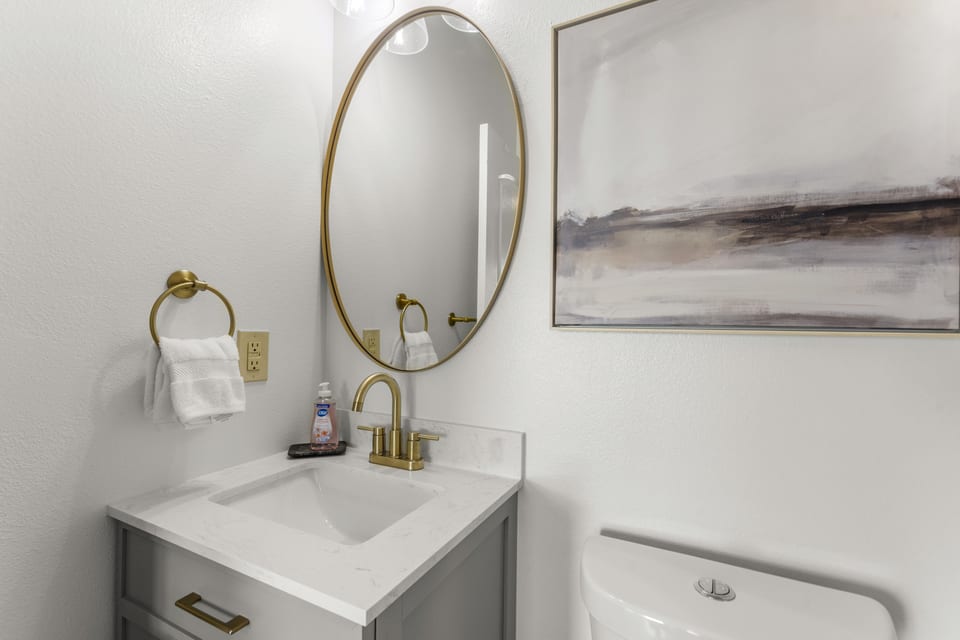 Vanity with round mirror and brass fittings