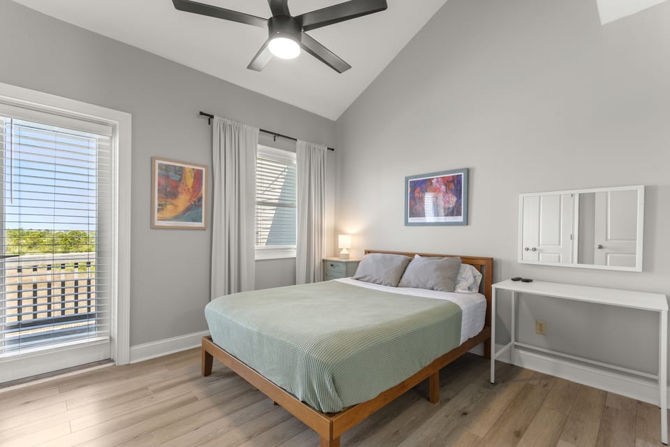 Guest suite with queen bed under a vaulted ceiling